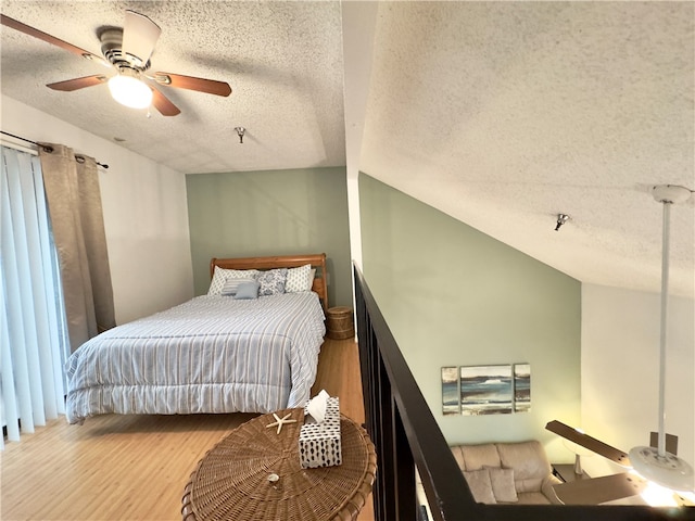 bedroom featuring a textured ceiling, ceiling fan, vaulted ceiling, and hardwood / wood-style flooring