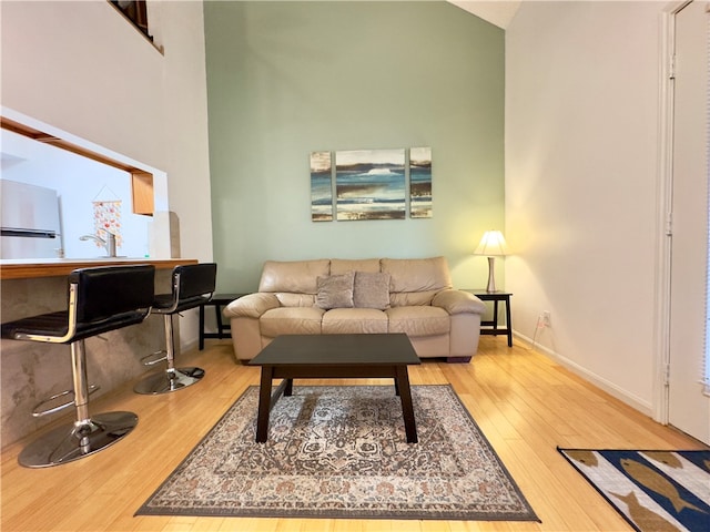 living room featuring wood-type flooring and high vaulted ceiling