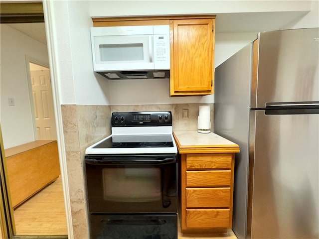 kitchen featuring decorative backsplash and white appliances