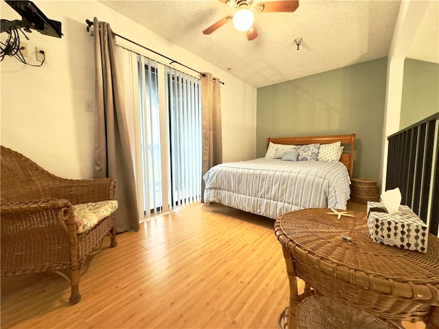 bedroom featuring hardwood / wood-style floors, ceiling fan, lofted ceiling, and a textured ceiling