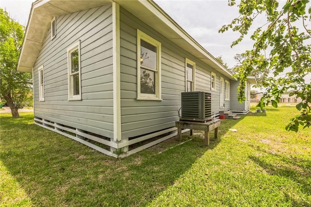 130 N Houston St, Aransas Pass, TX 78336 - view of home's exterior with a lawn and central AC unit