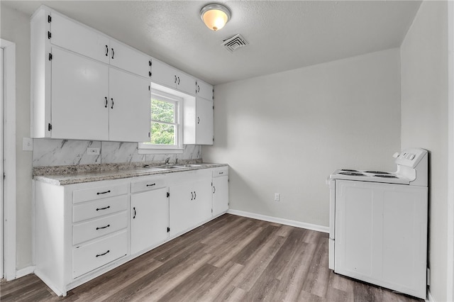130 N Houston St, Aransas Pass, TX 78336 - kitchen featuring white cabinets, white electric range, light countertops, visible vents, and dark wood-type flooring