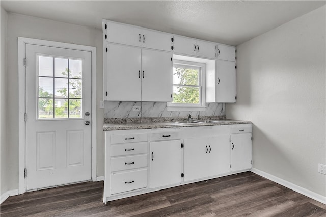 130 N Houston St, Aransas Pass, TX 78336 - kitchen with white cabinets, baseboards, a sink, and dark wood finished floors