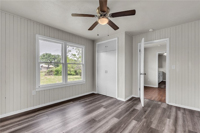 130 N Houston St, Aransas Pass, TX 78336 - unfurnished bedroom featuring wooden walls, wood finished floors, a closet, and baseboards