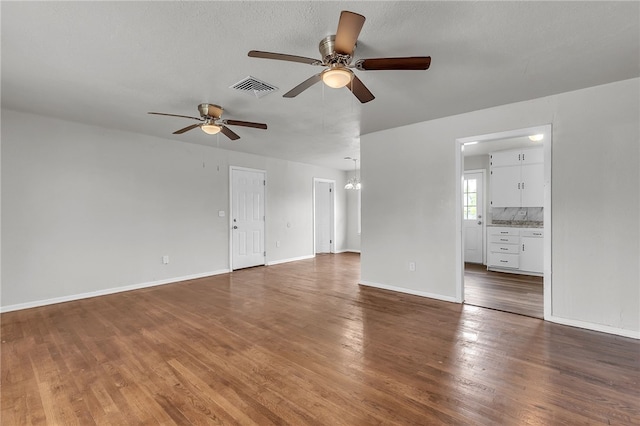 130 N Houston St, Aransas Pass, TX 78336 - unfurnished living room with wood finished floors, visible vents, a ceiling fan, and baseboards