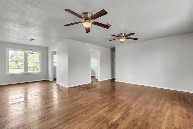 130 N Houston St, Aransas Pass, TX 78336 - unfurnished living room featuring wood finished floors, visible vents, baseboards, and ceiling fan with notable chandelier