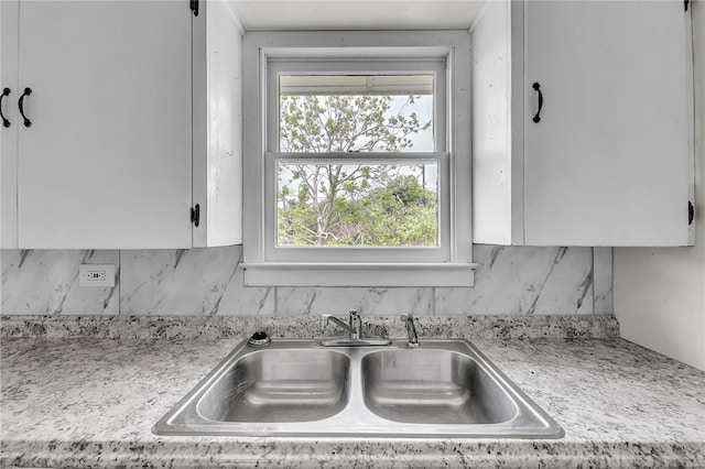 130 N Houston St, Aransas Pass, TX 78336 - kitchen with a sink, white cabinetry, and tasteful backsplash