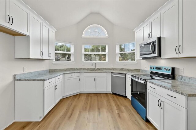 7821 Kingshire Dr, Corpus Christi, TX 78413 - kitchen with appliances with stainless steel finishes, lofted ceiling, light wood-style flooring, white cabinets, and light stone counters