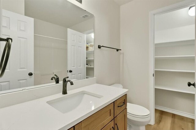 7821 Kingshire Dr, Corpus Christi, TX 78413 - full bathroom with vanity, wood finished floors, a shower, and a walk in closet