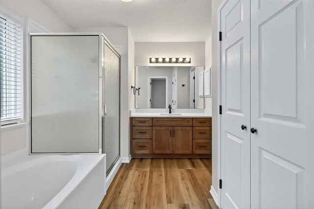 7821 Kingshire Dr, Corpus Christi, TX 78413 - full bath featuring a shower stall, vanity, wood finished floors, and a garden tub