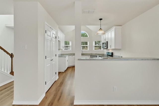 7821 Kingshire Dr, Corpus Christi, TX 78413 - kitchen featuring appliances with stainless steel finishes, light wood-type flooring, white cabinetry, a peninsula, and vaulted ceiling