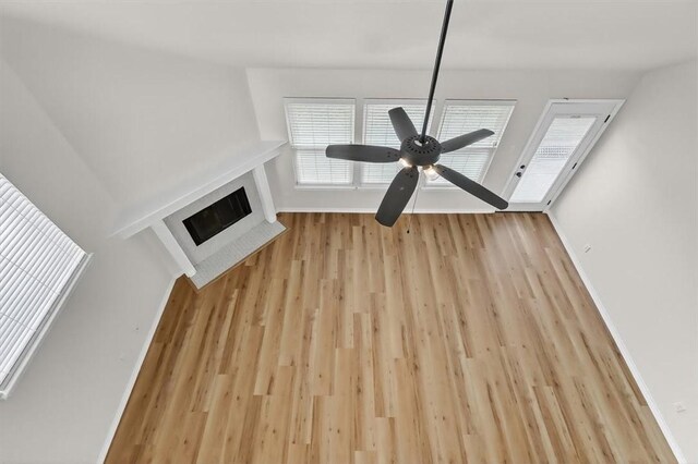 7821 Kingshire Dr, Corpus Christi, TX 78413 - unfurnished living room with wood finished floors, a ceiling fan, a fireplace with flush hearth, and healthy amount of natural light