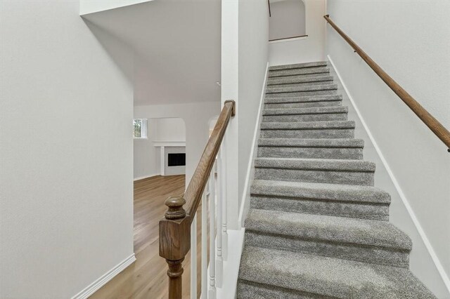 7821 Kingshire Dr, Corpus Christi, TX 78413 - stairway featuring wood finished floors and a fireplace