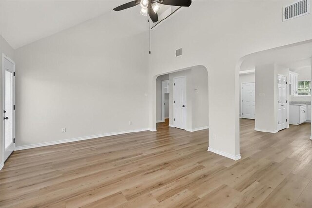 7821 Kingshire Dr, Corpus Christi, TX 78413 - unfurnished living room with a ceiling fan, high vaulted ceiling, arched walkways, and light wood-type flooring