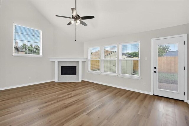 7821 Kingshire Dr, Corpus Christi, TX 78413 - unfurnished living room with wood finished floors, vaulted ceiling, a fireplace, and a ceiling fan