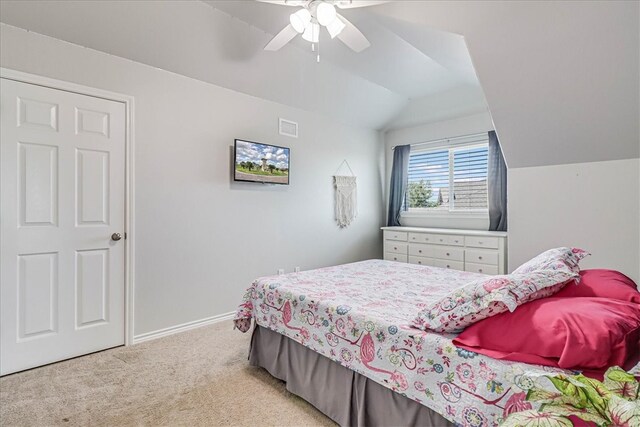 carpeted bedroom with ceiling fan and vaulted ceiling