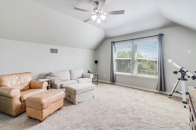 carpeted living room with ceiling fan and vaulted ceiling