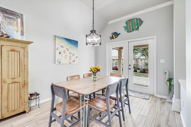 dining room featuring light hardwood / wood-style floors, an inviting chandelier, and lofted ceiling