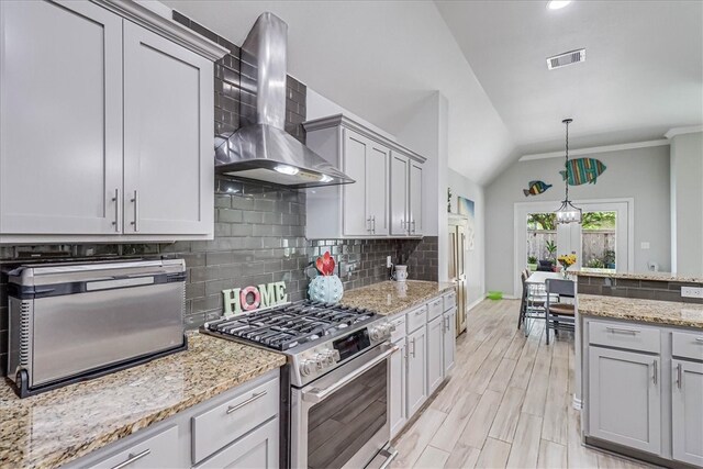 kitchen featuring tasteful backsplash, ornamental molding, stainless steel stove, lofted ceiling, and wall chimney exhaust hood