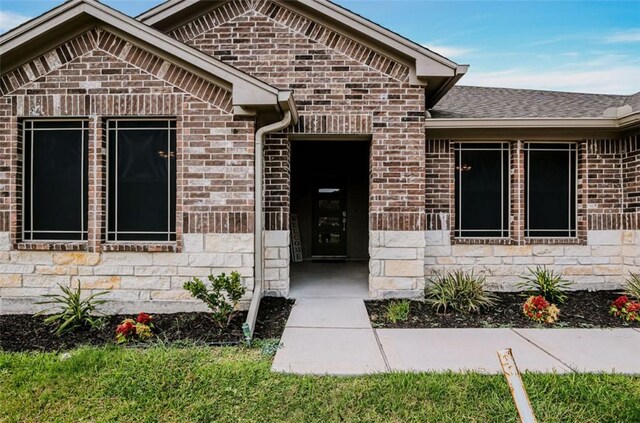 7602 Bayley Ln, Corpus Christi, TX 78414 - property entrance with brick siding, a shingled roof, and stone siding