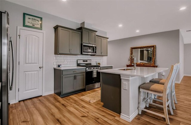 7602 Bayley Ln, Corpus Christi, TX 78414 - kitchen featuring appliances with stainless steel finishes, a sink, light wood-type flooring, light countertops, and recessed lighting