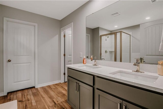 7602 Bayley Ln, Corpus Christi, TX 78414 - full bathroom with a shower stall, double vanity, wood finished floors, baseboards, and recessed lighting