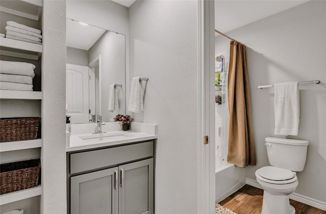 7602 Bayley Ln, Corpus Christi, TX 78414 - bathroom with vanity, toilet, wood finished floors, baseboards, and shower / tub combo