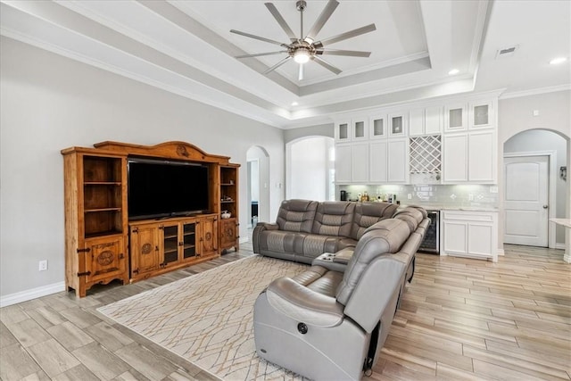 living room with ceiling fan, crown molding, wine cooler, and a raised ceiling