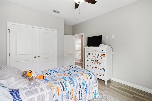 bedroom featuring ceiling fan, a closet, and light hardwood / wood-style flooring