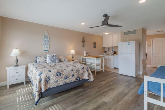 bedroom featuring light hardwood / wood-style flooring and white refrigerator