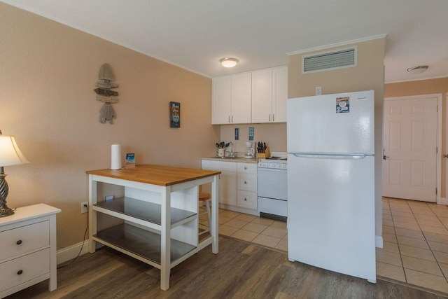 kitchen featuring crown molding, white appliances, wooden counters, wood-type flooring, and white cabinets