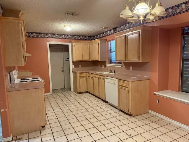 6026 Blue Water Dr, Corpus Christi, TX 78415 - kitchen with white appliances, light brown cabinetry, a chandelier, a textured ceiling, and light tile patterned floors