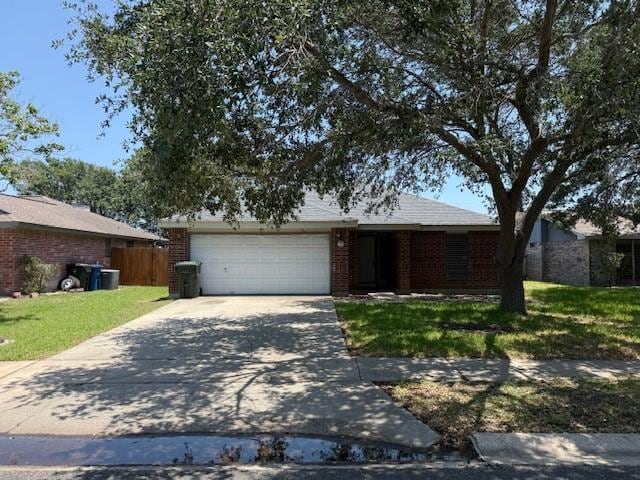 6026 Blue Water Dr, Corpus Christi, TX 78415 - view of front of home featuring concrete driveway, an attached garage, and brick siding