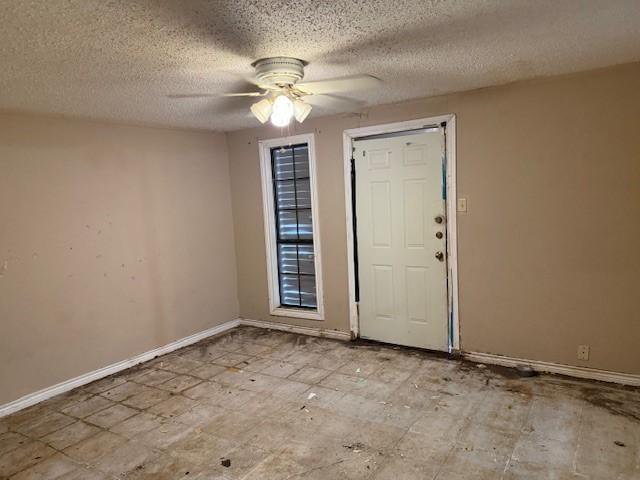 6026 Blue Water Dr, Corpus Christi, TX 78415 - foyer entrance featuring ceiling fan, a textured ceiling, and baseboards