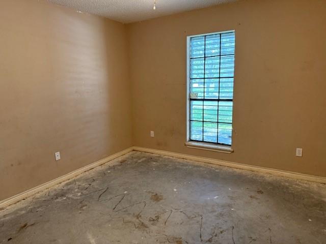 6026 Blue Water Dr, Corpus Christi, TX 78415 - spare room with baseboards and a textured ceiling