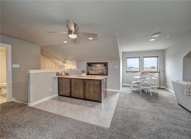 kitchen with light colored carpet, a peninsula, baseboards, open floor plan, and light countertops