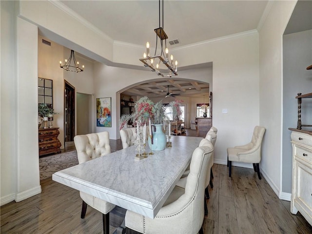 dining room with baseboards, visible vents, arched walkways, and wood finished floors