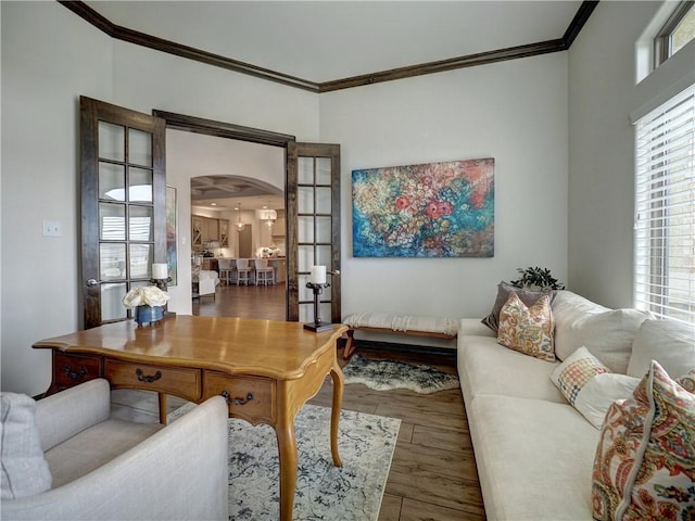 home office with arched walkways, ornamental molding, and dark wood-style flooring