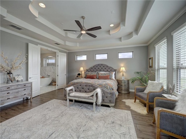 bedroom with dark wood-style floors, a tray ceiling, visible vents, and ornamental molding