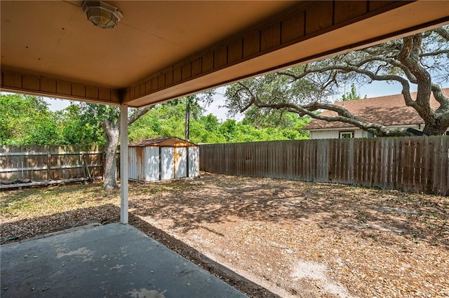 view of yard with a fenced backyard, an outbuilding, a patio, and a storage unit