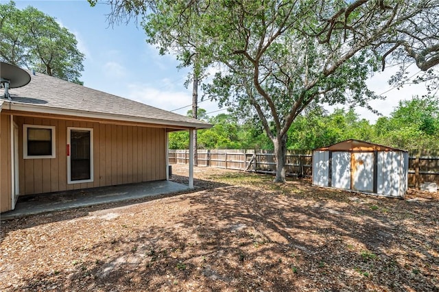 view of yard featuring a fenced backyard, an outbuilding, a patio area, and a shed