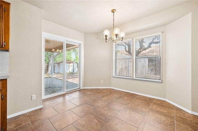 unfurnished dining area featuring baseboards and an inviting chandelier