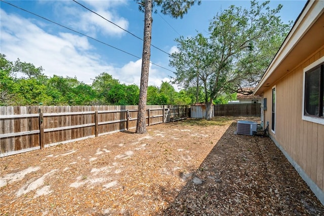 view of yard with a fenced backyard and central air condition unit