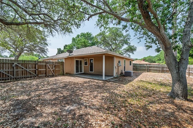 rear view of house with a fenced backyard, a gate, central air condition unit, and a patio