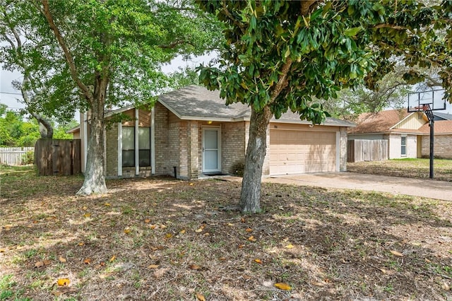view of front of property with an attached garage, brick siding, fence, and driveway