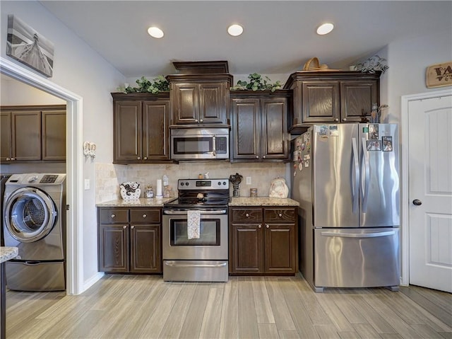 kitchen featuring stainless steel appliances, washer / clothes dryer, light wood-type flooring, and dark brown cabinetry