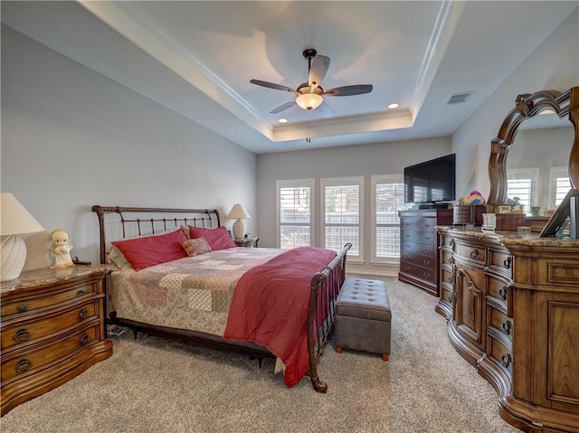 carpeted bedroom featuring ceiling fan, crown molding, and a raised ceiling