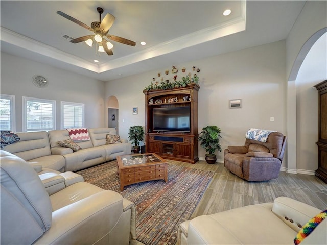 living room featuring ceiling fan and a tray ceiling