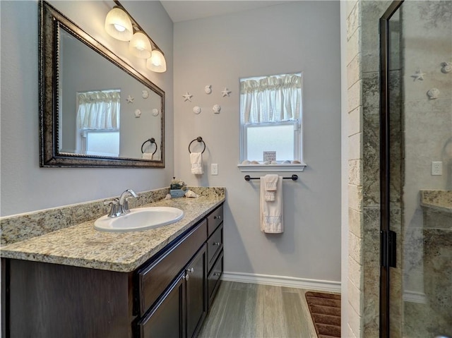 bathroom with vanity, a shower with shower door, and hardwood / wood-style flooring