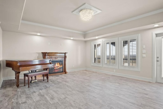 miscellaneous room featuring a chandelier, light hardwood / wood-style floors, ornamental molding, and a tray ceiling